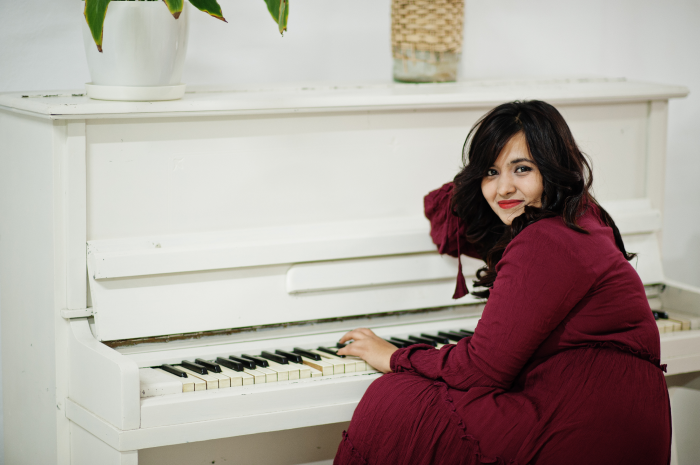 Summer Piano Lessons Ireland attractive south asian woman deep red gown dress posed room play piano 1